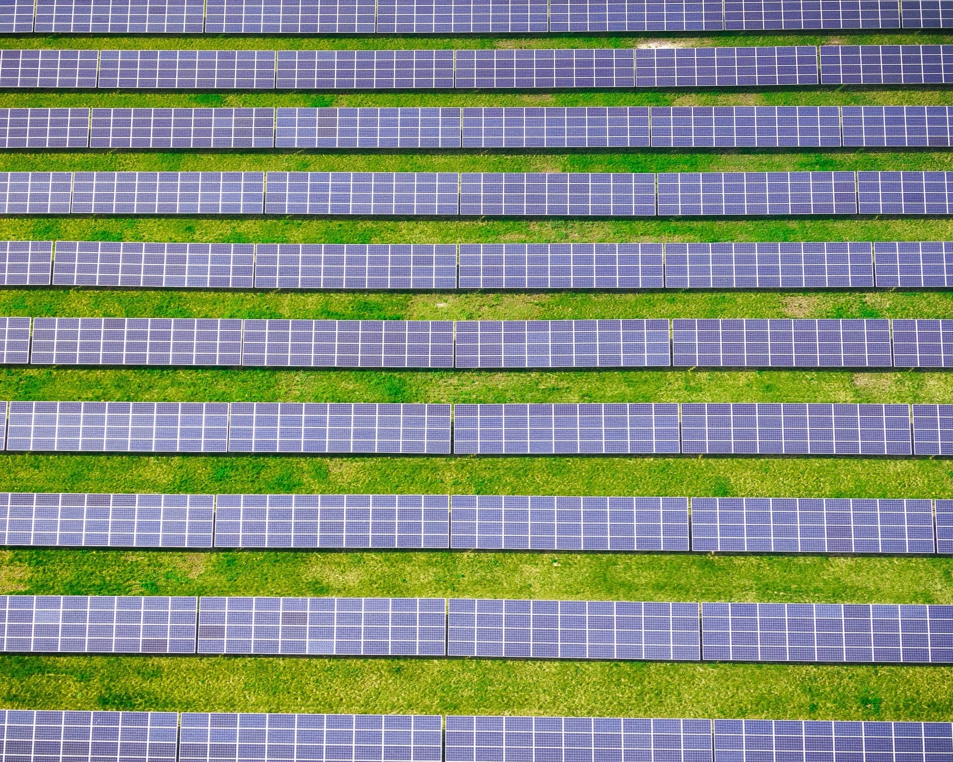 Luchtfoto van rijen zonnepanelen op grasland